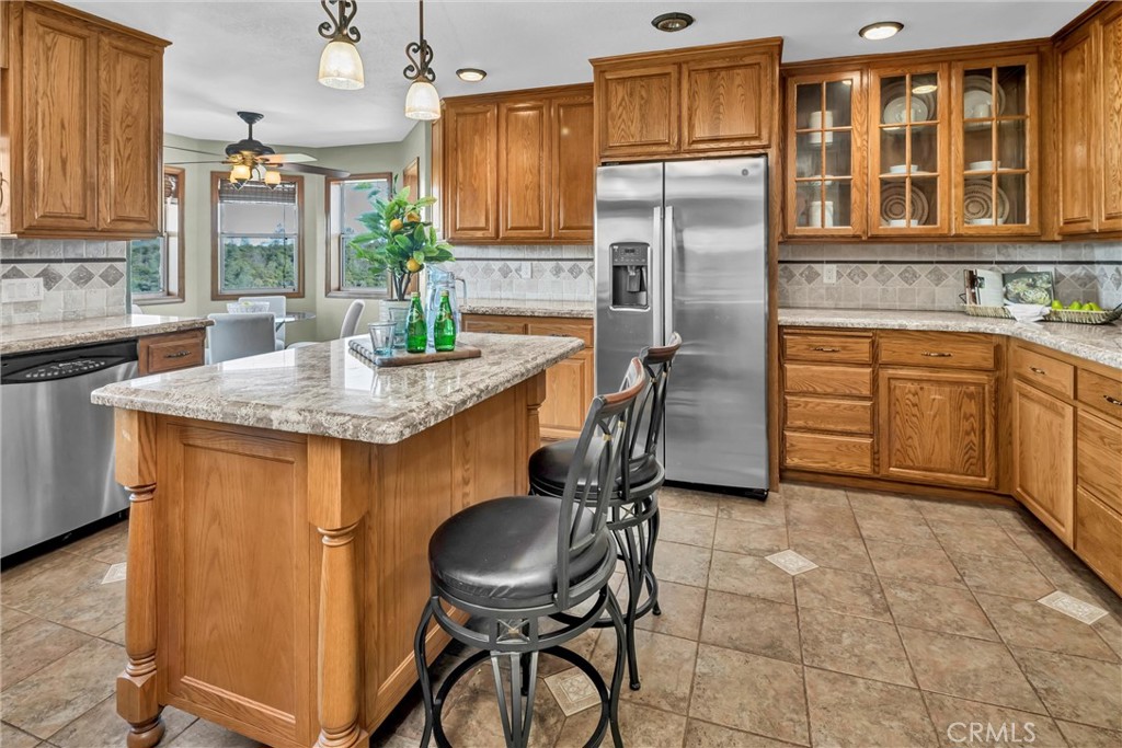 20250 Black Bass Pass Road Lower Lake, CA 95457 - Photo 21 of 66 a kitchen with stainless steel appliances granite countertop a stove a sink a refrigerator dining table and chairs