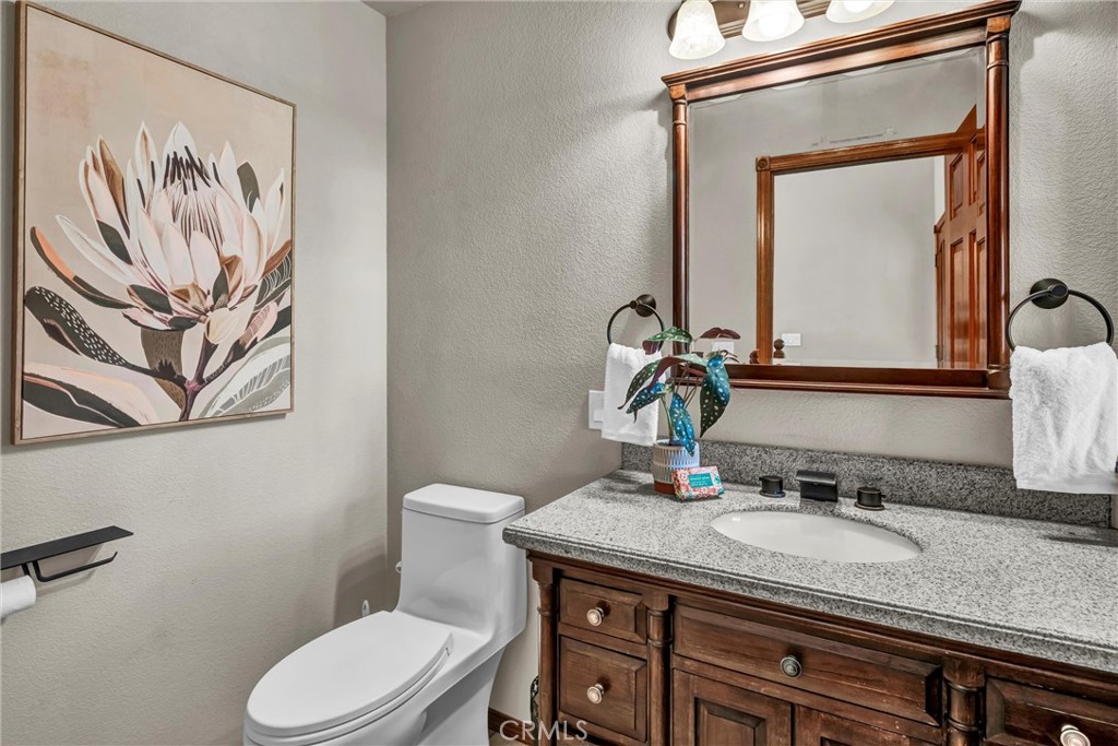 20250 Black Bass Pass Road Lower Lake, CA 95457 - Photo 26 of 66 a bathroom with a granite countertop toilet sink and mirror