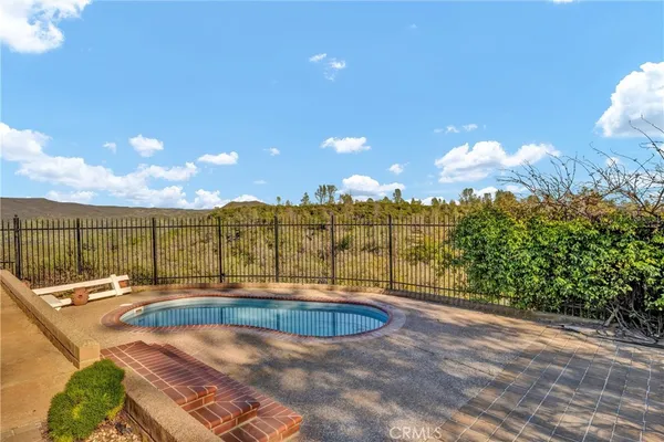 a view of swimming pool with a big yard and large trees