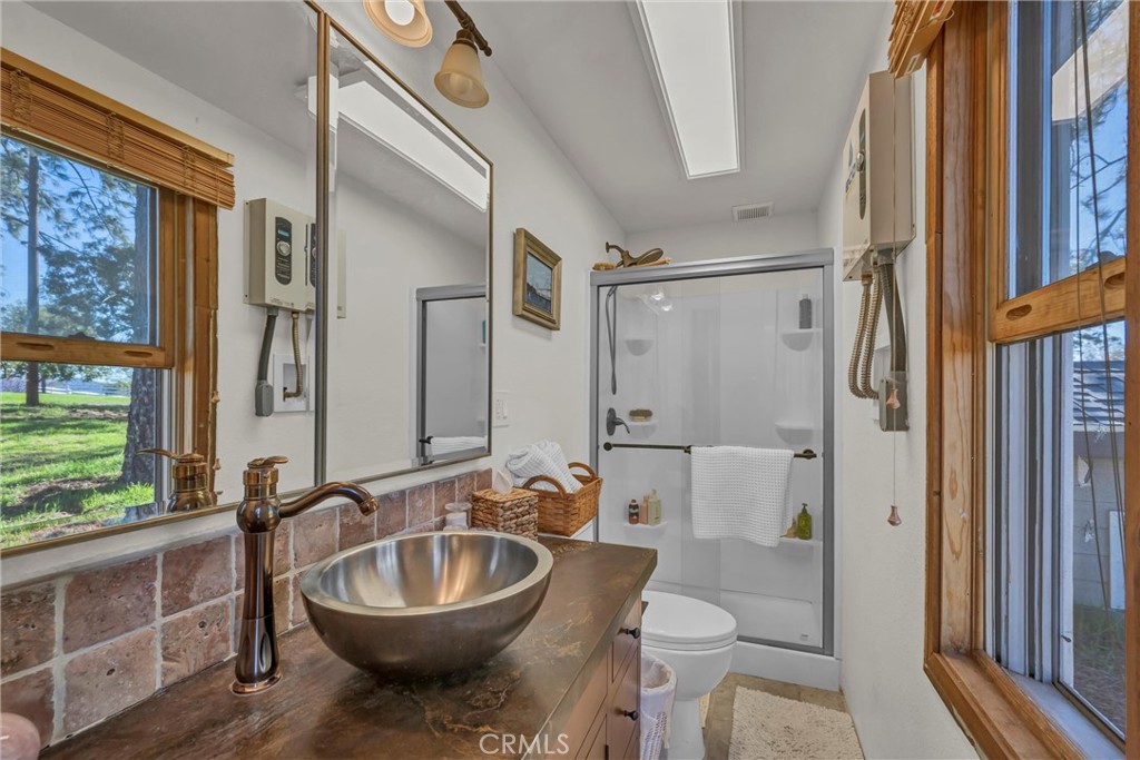 20250 Black Bass Pass Road Lower Lake, CA 95457 - Photo 55 of 66 a bathroom with a granite countertop toilet a sink and a bathtub