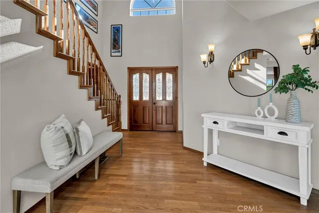 a living room with couches and a dining table with wooden floor