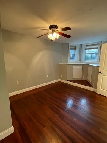 a view of a room with wooden floor and fan