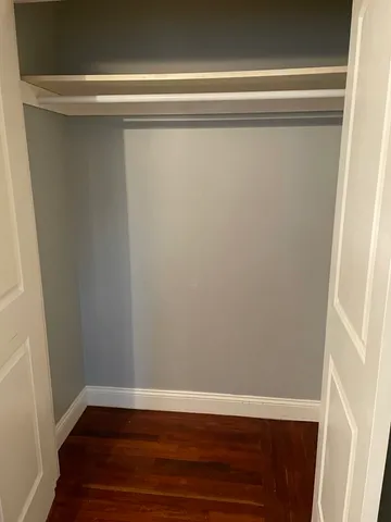a view of a closet with wooden floor