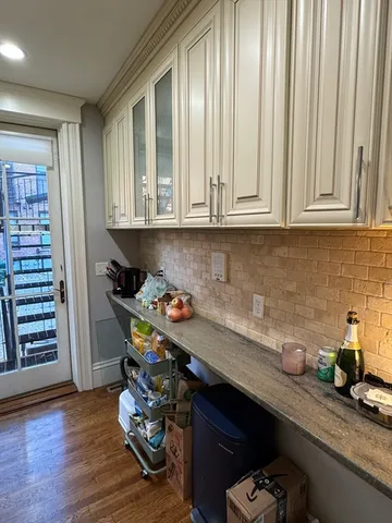 a kitchen with granite countertop a sink cabinets and wooden floor