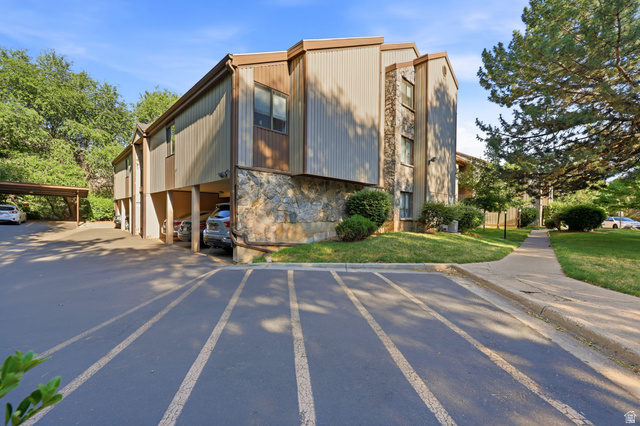 1175 Canyon Road, Unit 86 Ogden, UT 84404 - Photo 24 of 29 Multi-level residential building featuring stone facade elements, vertical siding, and a covered parking area