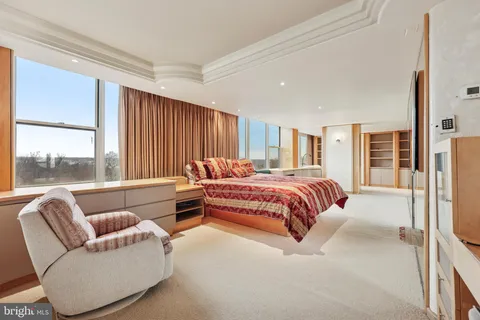 a dining room with furniture and a floor to ceiling window