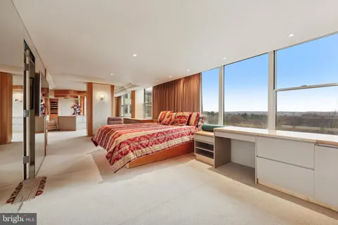 a bedroom with furniture and large window