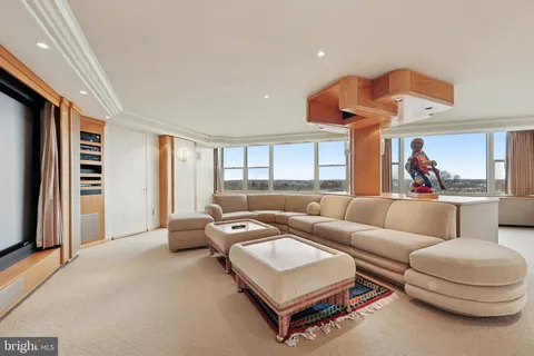 a living room with furniture a flat screen tv and a window