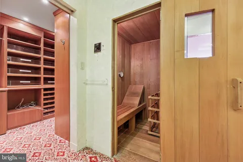 a view of a hallway to a livingroom with furniture and an entrance