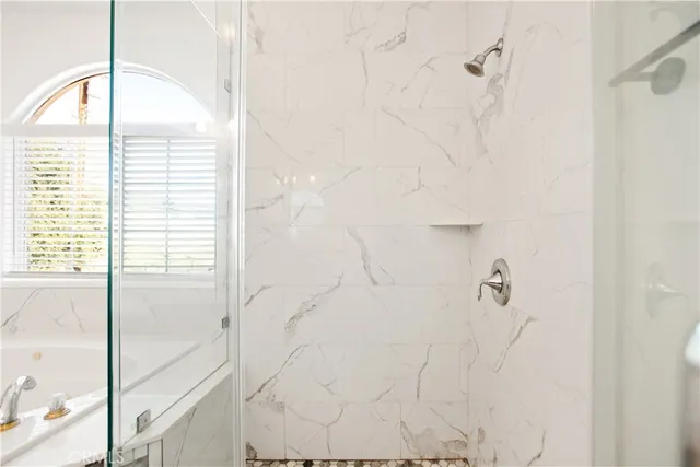 a bathroom with a glass door shower and a sink