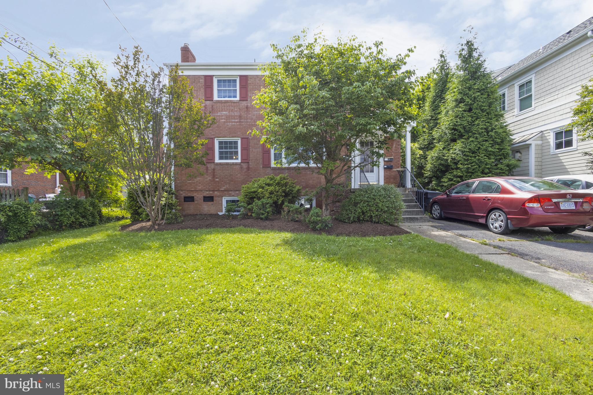 a front view of a house with a yard and trees