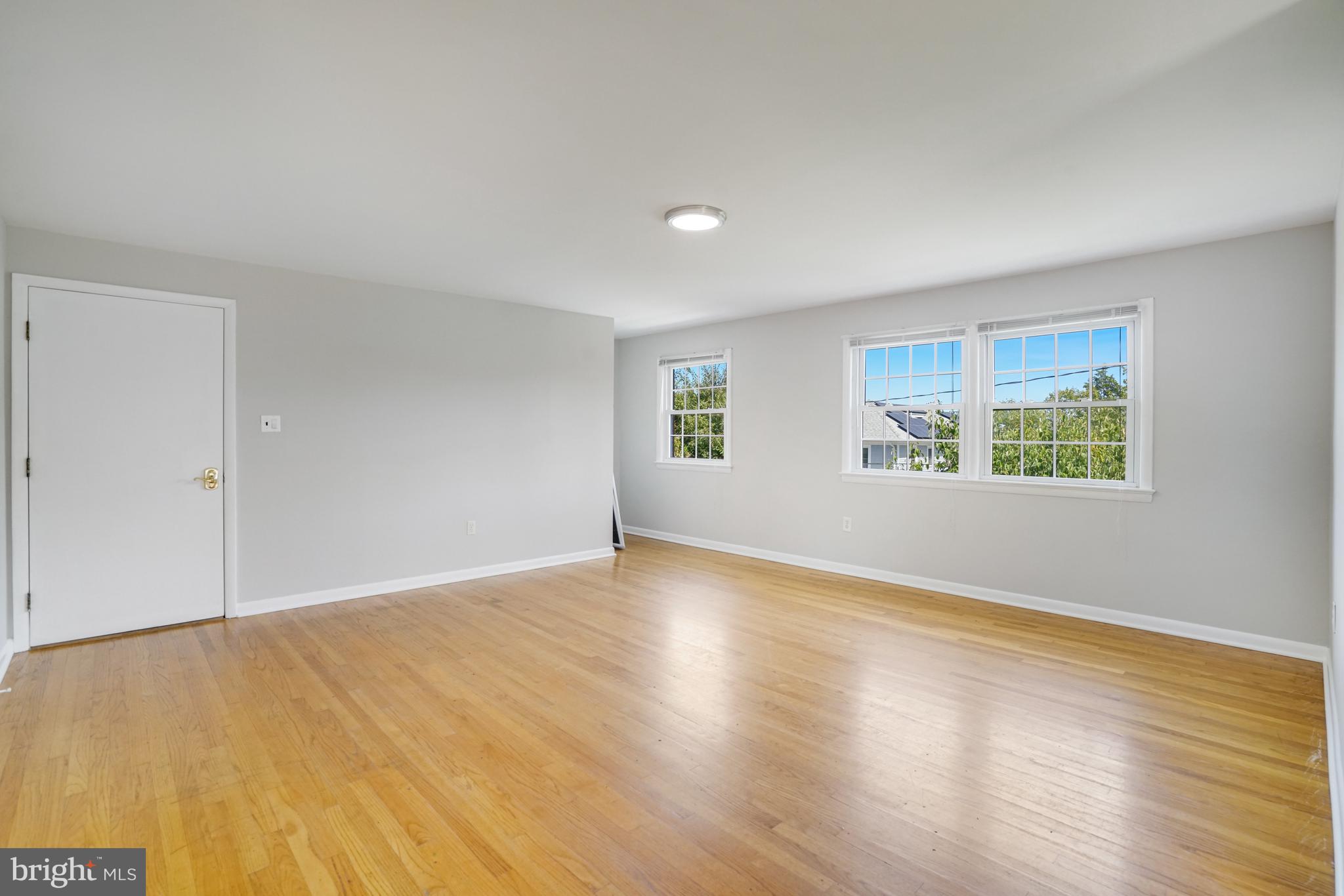 706 North Cleveland Street Arlington, VA 22201 - Photo 5 of 59 a view of an empty room with wooden floor and a window