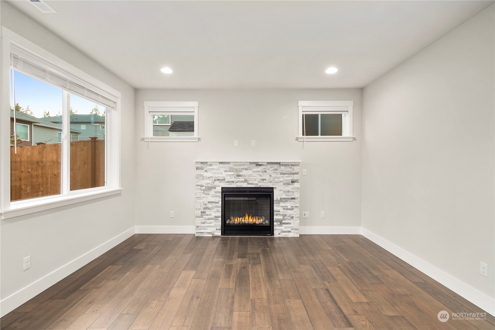 1302 197th Place Southeast Bothell, WA 98012 - Photo 11 of 35 an empty room with wooden floor fireplace and windows