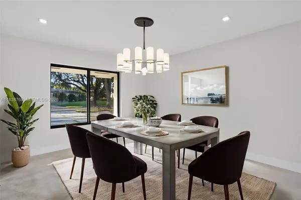 a view of a dining room with furniture a chandelier and window