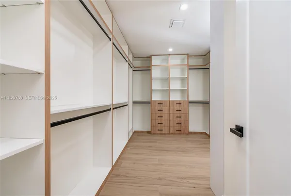 a view of walk in closet with empty racks