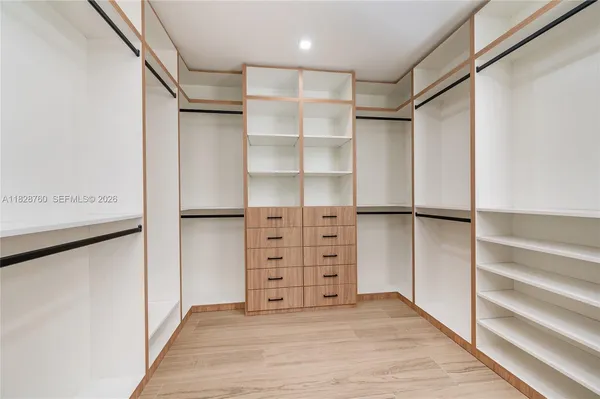 a view of walk in closet with empty racks