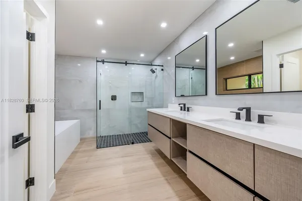a spacious bathroom with a shower a sink and mirror
