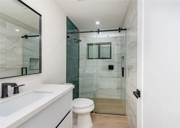 a bathroom with a sink a toilet and shower