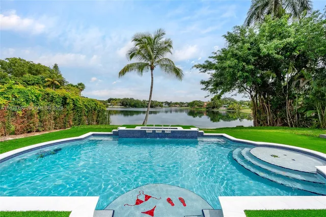 a view of a swimming pool with a bench and trees