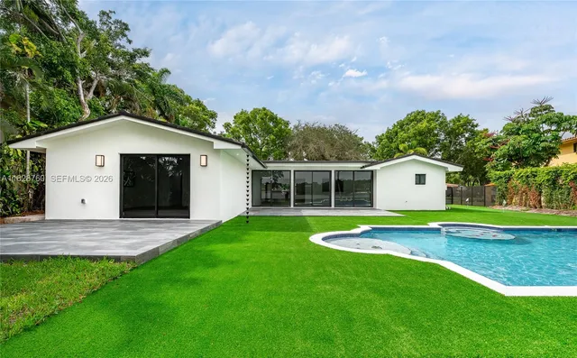 a view of a house with a yard and a large tree