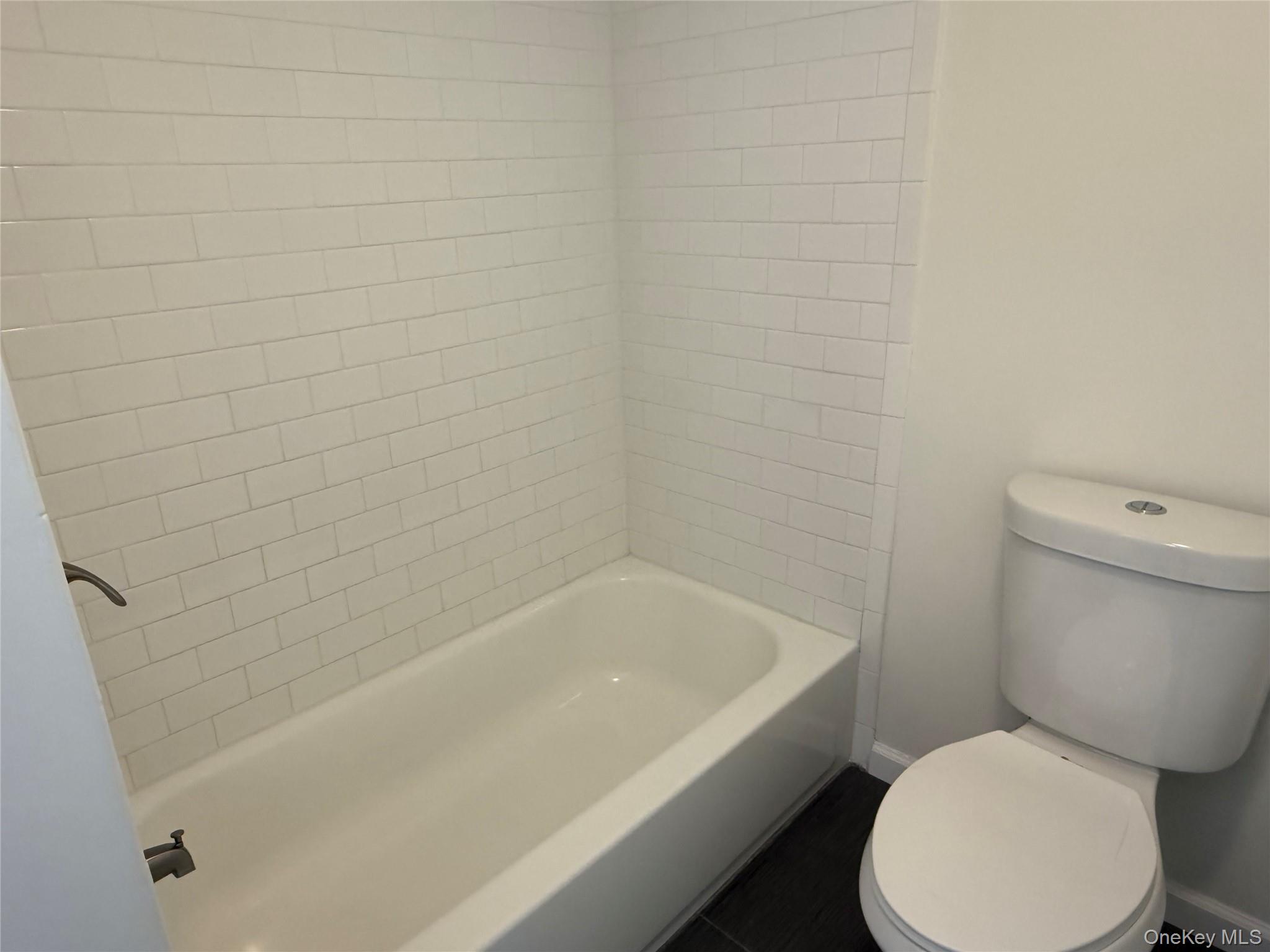 225 Fir Grove Road Ronkonkoma, NY 11779 - Photo 11 of 22 a white toilet sitting next to a bathtub