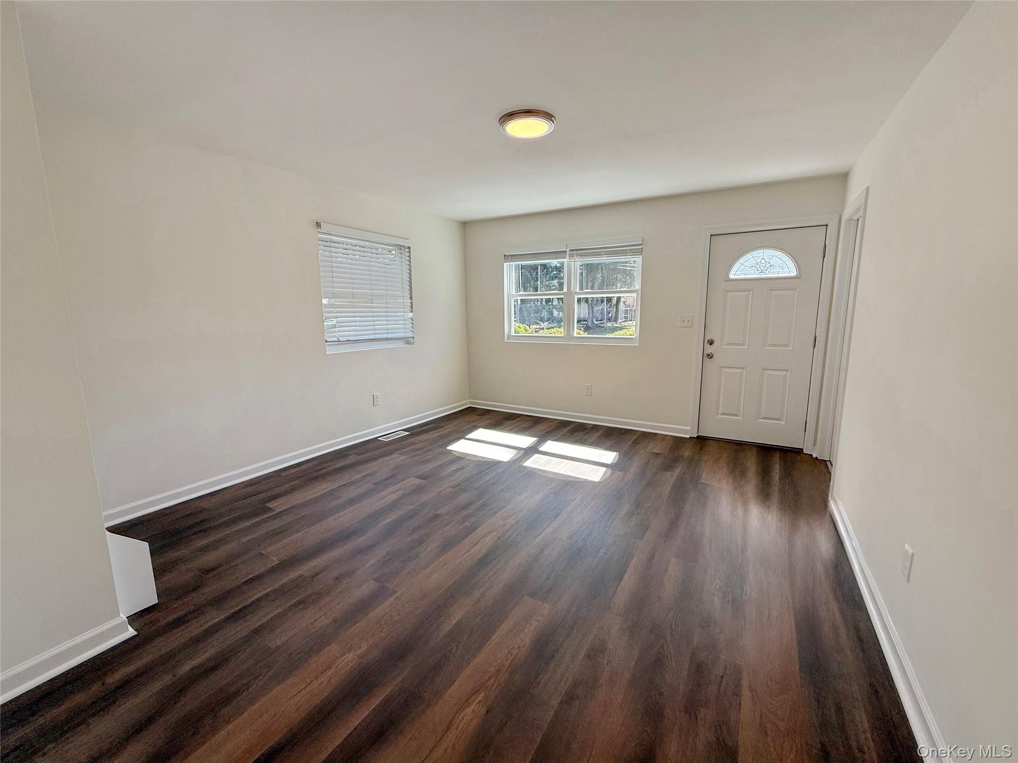 225 Fir Grove Road Ronkonkoma, NY 11779 - Photo 15 of 22 an empty room with wooden floor and windows