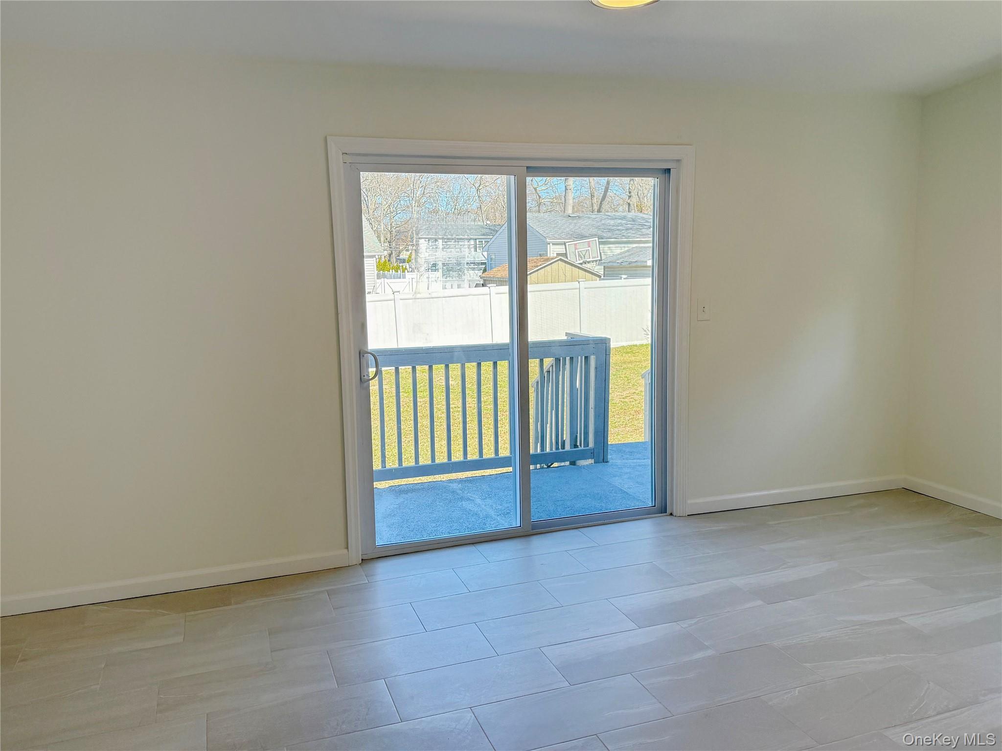 225 Fir Grove Road Ronkonkoma, NY 11779 - Photo 8 of 22 an empty room with sliding door