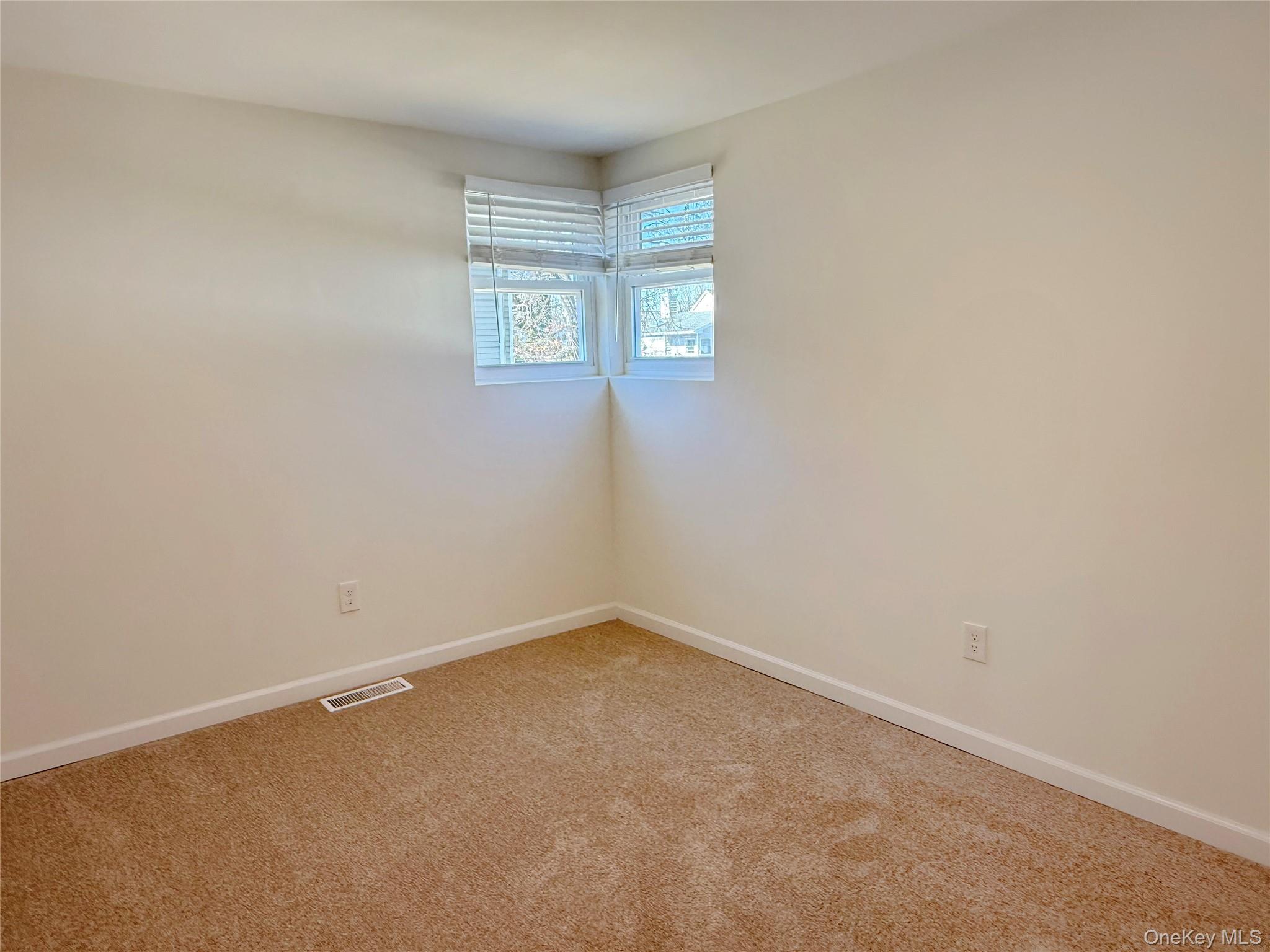 225 Fir Grove Road Ronkonkoma, NY 11779 - Photo 9 of 22 an empty room with windows
