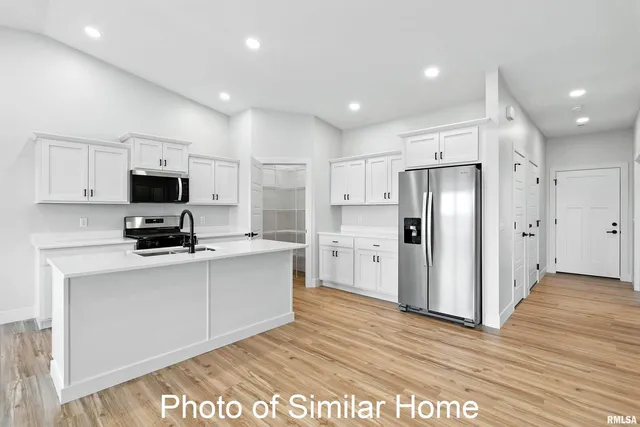 a kitchen with stainless steel appliances granite countertop a sink a stove a refrigerator and cabinets