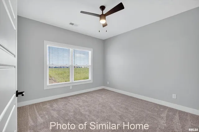 an empty room with closet and a ceiling fan