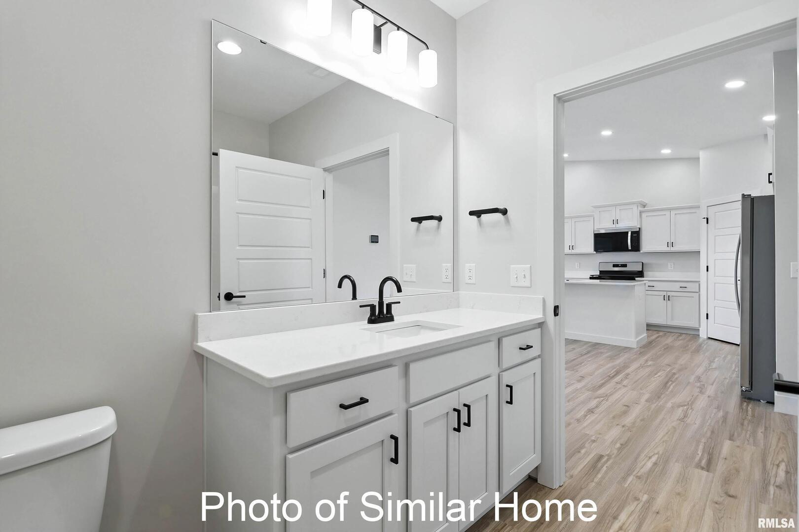 559 North 4th Avenue Eldridge, IA 52748 - Photo 23 of 31 a spacious bathroom with a sink a toilet a mirror and shower