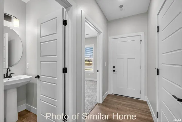 a view of bathroom with a sink mirror and window