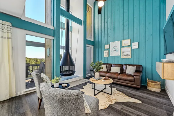 a living room with furniture floor to ceiling window and wooden floor