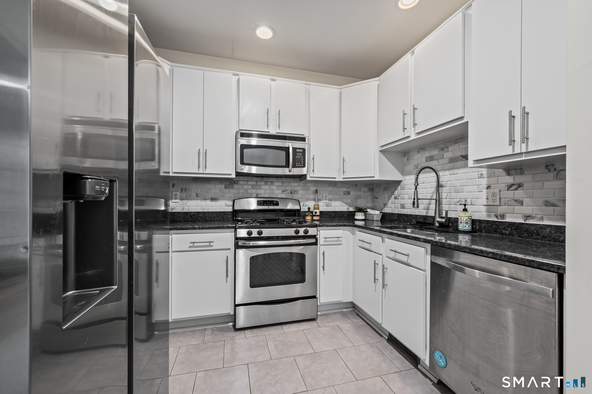 23 Rhodora Terrace, Unit 23 Windsor, CT 06095 - Photo 12 of 36 Kitchen with French door refrigerator, stainless steel appliances, tiled backsplash and more.