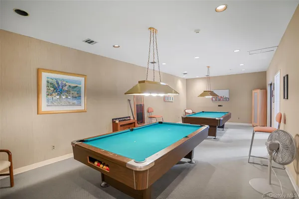 a room with pool table and windows