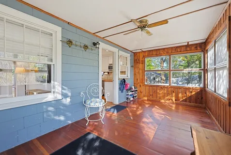 a view of a living room with a floor to ceiling window and wooden floor