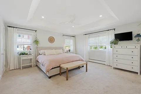 a spacious bedroom with a bed and a television