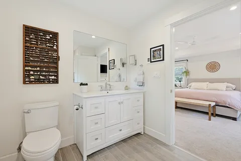 a spacious bathroom with a toilet a sink and a mirror