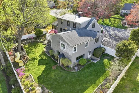 a aerial view of a house with a big yard and large trees