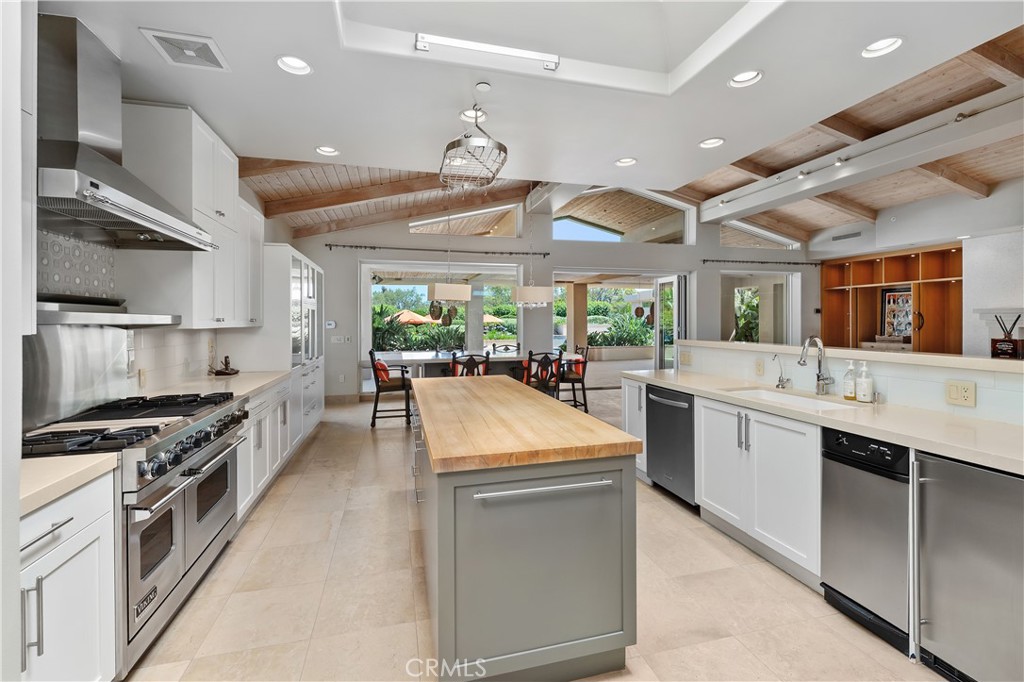 6533 Lago Lindo Rancho Santa Fe, CA 92067 - Photo 24 of 57 a large kitchen with stainless steel appliances lots of counter space and wooden floor