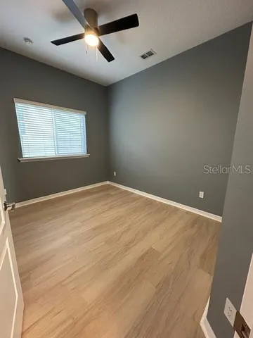 a view of empty room with wooden floor