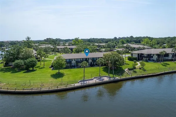 an aerial view of a house with a garden and lake view