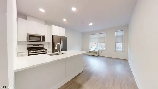 a view of a kitchen with wooden floor and a sink