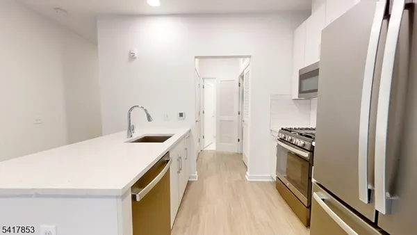a kitchen with a sink stainless steel appliances and cabinets