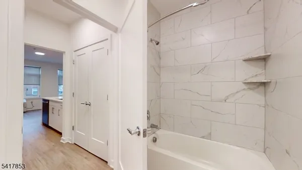 a view of a kitchen with refrigerator and wooden floor