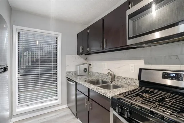 a kitchen with granite countertop a stove and a sink