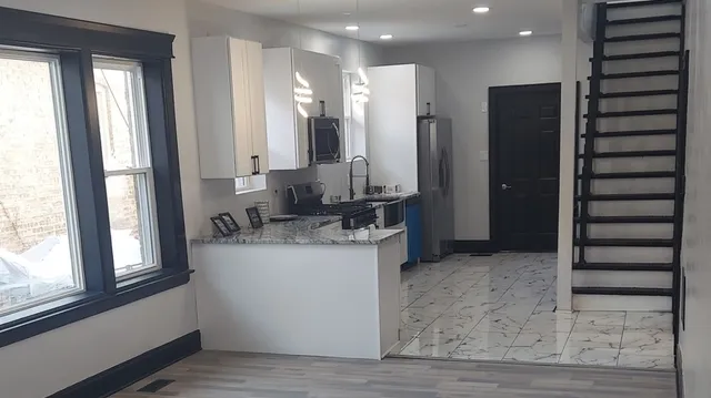 a kitchen with stainless steel appliances granite countertop a refrigerator and a sink