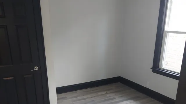 a small space with wooden floor and a window