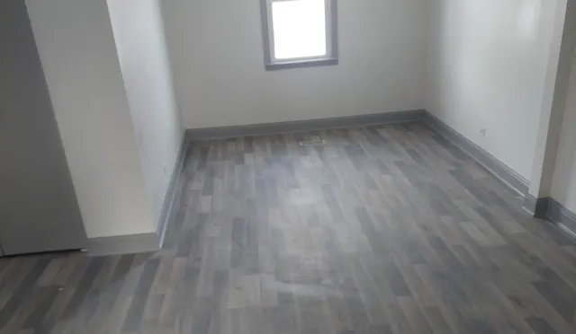 a view of a room with wooden floor and window