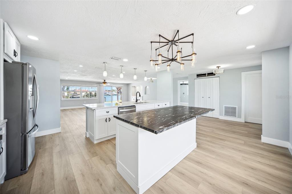 6410 3rd Palm Point St. Pete Beach, FL 33706 - Photo 11 of 54 a kitchen with stainless steel appliances granite countertop a lot of counter space and wooden floors